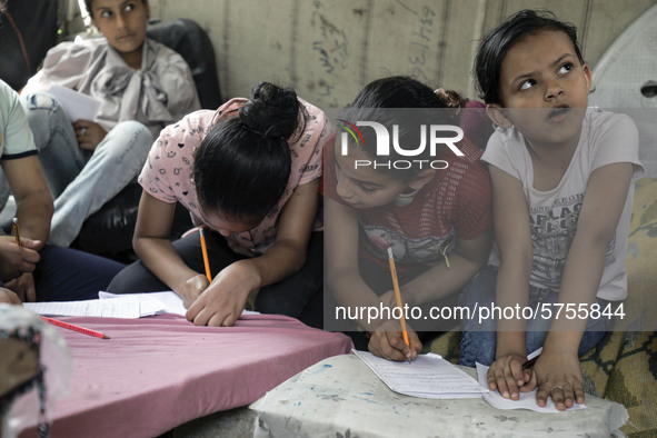 Children attend an Arabic language lesson given by a Palestinian school girl Fajr Hmaid, 13, as schools are shut due to the coronavirus dise...