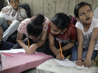 Children attend an Arabic language lesson given by a Palestinian school girl Fajr Hmaid, 13, as schools are shut due to the coronavirus dise...