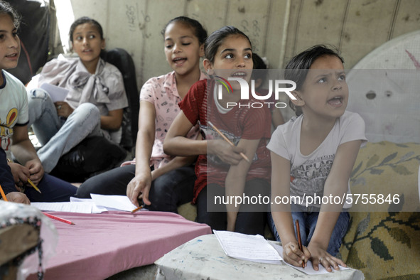 Children attend an Arabic language lesson given by a Palestinian school girl Fajr Hmaid, 13, as schools are shut due to the coronavirus dise...