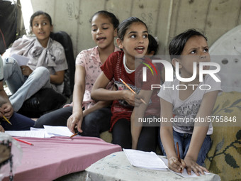 Children attend an Arabic language lesson given by a Palestinian school girl Fajr Hmaid, 13, as schools are shut due to the coronavirus dise...