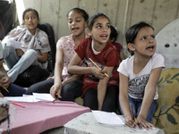 Children attend an Arabic language lesson given by a Palestinian school girl Fajr Hmaid, 13, as schools are shut due to the coronavirus dise...