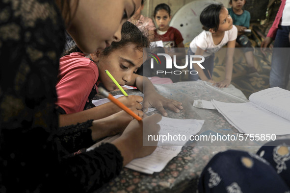 Children attend an Arabic language lesson given by a Palestinian school girl Fajr Hmaid, 13, as schools are shut due to the coronavirus dise...