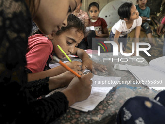 Children attend an Arabic language lesson given by a Palestinian school girl Fajr Hmaid, 13, as schools are shut due to the coronavirus dise...