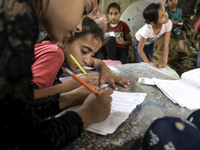 Children attend an Arabic language lesson given by a Palestinian school girl Fajr Hmaid, 13, as schools are shut due to the coronavirus dise...