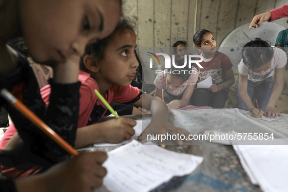 Children attend an Arabic language lesson given by a Palestinian school girl Fajr Hmaid, 13, as schools are shut due to the coronavirus dise...