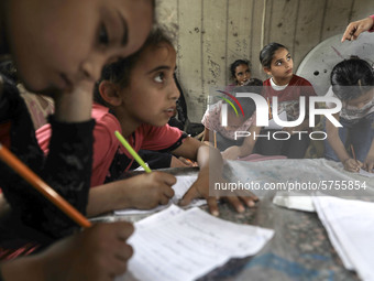 Children attend an Arabic language lesson given by a Palestinian school girl Fajr Hmaid, 13, as schools are shut due to the coronavirus dise...