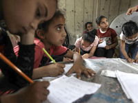 Children attend an Arabic language lesson given by a Palestinian school girl Fajr Hmaid, 13, as schools are shut due to the coronavirus dise...