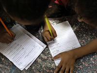 Children attend an Arabic language lesson given by a Palestinian school girl Fajr Hmaid, 13, as schools are shut due to the coronavirus dise...