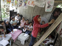 A Palestinian school girl Fajr Hmaid, 13, teaches her neighbours' children an Arabic language lesson as schools are shut due to the coronavi...