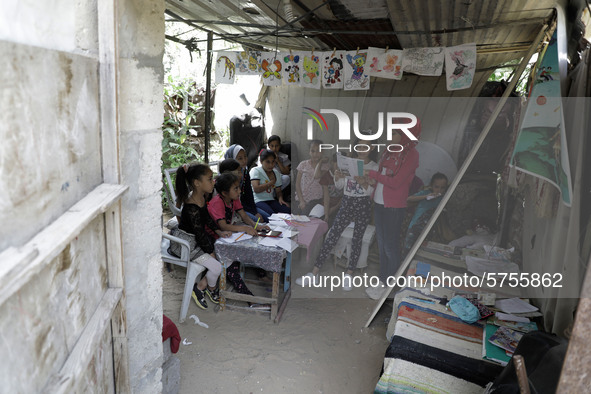 A Palestinian school girl Fajr Hmaid, 13, teaches her neighbours' children an Arabic language lesson as schools are shut due to the coronavi...