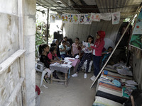 A Palestinian school girl Fajr Hmaid, 13, teaches her neighbours' children an Arabic language lesson as schools are shut due to the coronavi...