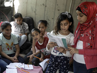 A Palestinian school girl Fajr Hmaid, 13, teaches her neighbours' children an Arabic language lesson as schools are shut due to the coronavi...