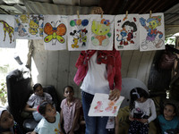 A Palestinian school girl Fajr Hmaid, 13, teaches her neighbours' children an Arabic language lesson as schools are shut due to the coronavi...