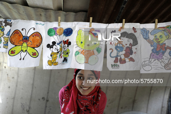 A Palestinian school girl Fajr Hmaid, 13, teaches her neighbours' children an Arabic language lesson as schools are shut due to the coronavi...