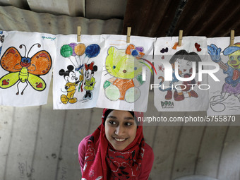 A Palestinian school girl Fajr Hmaid, 13, teaches her neighbours' children an Arabic language lesson as schools are shut due to the coronavi...