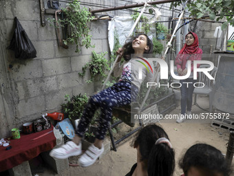 A Palestinian school girl Fajr Hmaid, 13, teaches her neighbours' children an Arabic language lesson as schools are shut due to the coronavi...