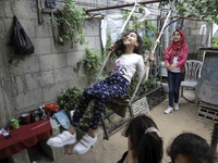 A Palestinian school girl Fajr Hmaid, 13, teaches her neighbours' children an Arabic language lesson as schools are shut due to the coronavi...