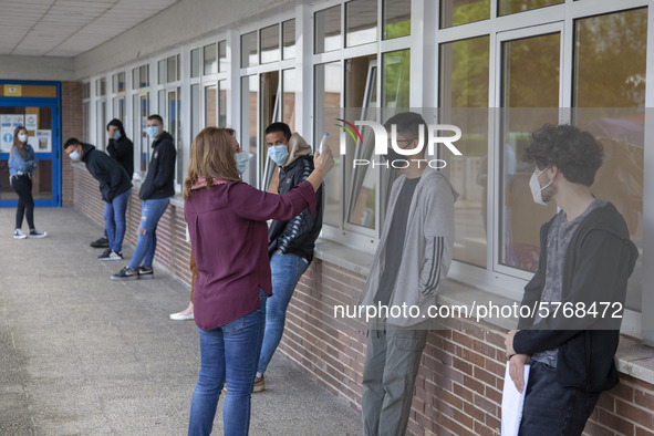 A school worker takes the temperature of each student before entering the classroom in Norena, Spain, on June 8, 2020. Spanish high school s...