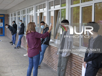 A school worker takes the temperature of each student before entering the classroom in Norena, Spain, on June 8, 2020. Spanish high school s...