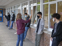 A school worker takes the temperature of each student before entering the classroom in Norena, Spain, on June 8, 2020. Spanish high school s...