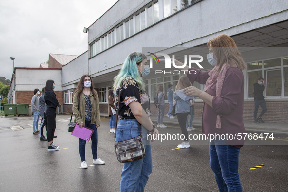 A school worker takes the temperature of each student before entering the classroom in Norena, Spain, on June 8, 2020. Spanish high school s...