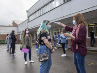 A school worker takes the temperature of each student before entering the classroom in Norena, Spain, on June 8, 2020. Spanish high school s...