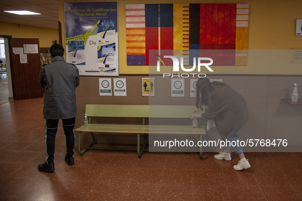 Two students disinfect their hands before entering the classroom in Norena, Spain, on June 8, 2020. The use of masks, disinfectant gels and...