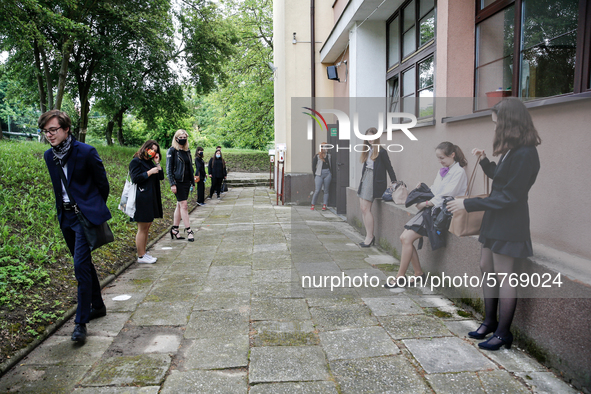 A group of young adults wait to be eadmited to examitation hall before taking final graduation exams, called maturity exams in the First Gen...