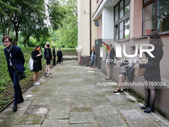 A group of young adults wait to be eadmited to examitation hall before taking final graduation exams, called maturity exams in the First Gen...