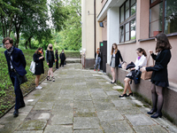 A group of young adults wait to be eadmited to examitation hall before taking final graduation exams, called maturity exams in the First Gen...