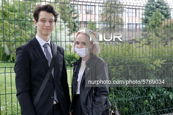 A couple of young adults pose to be photographed before taking final graduation exams, called maturity exams in the First General Education...