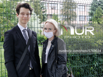 A couple of young adults pose to be photographed before taking final graduation exams, called maturity exams in the First General Education...