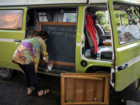 Giulia Zaffagnini, teacher, fixes the desk she uses during her itinerant lessons. On board of a 1970s van she goes under the house of studen...