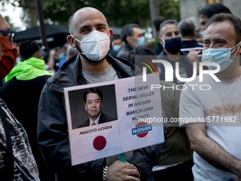 Nissan employees hold a photo of Nissan chief executive officer Makoto Uchida reading ''executioner'' during a protest against the closure o...