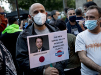 Nissan employees hold a photo of Nissan chief executive officer Makoto Uchida reading ''executioner'' during a protest against the closure o...