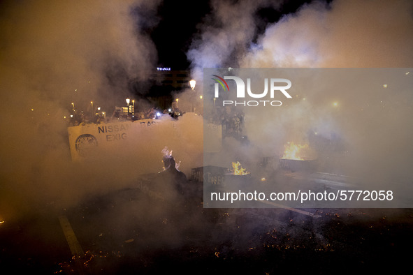 Nissan employees burn mock coffins while holding a banner reading ''Stop lies, we demand a real future'' during a protest against the closur...