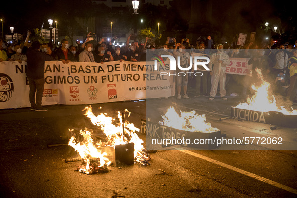 Nissan employees burn mock coffins while holding a banner reading ''Stop lies, we demand a real future'' during a protest against the closur...