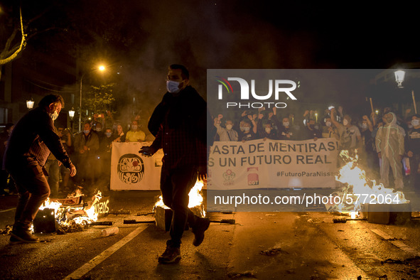 Nissan employees burn mock coffins while holding a banner reading ''Stop lies, we demand a real future'' during a protest against the closur...