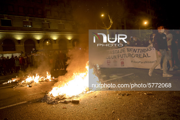 Nissan employees burn mock coffins while holding a banner reading ''Stop lies, we demand a real future'' during a protest against the closur...