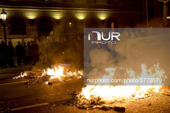 Nissan employees burn mock coffins while holding a banner reading ''Stop lies, we demand a real future'' during a protest against the closur...