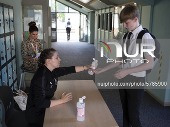   A teacher gives Year 10 pupils hand sanitizer. Ortu Gable Hall School in Corringham, Essex return after a long break due to the COVID-19 p...