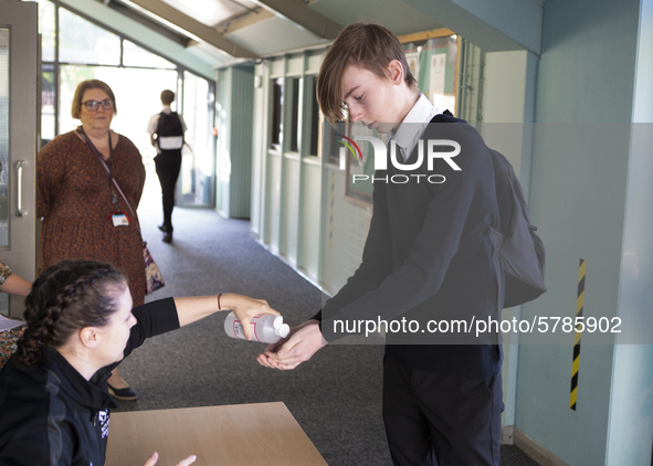   A teacher gives Year 10 pupils hand sanitizer. Ortu Gable Hall School in Corringham, Essex return after a long break due to the COVID-19 p...