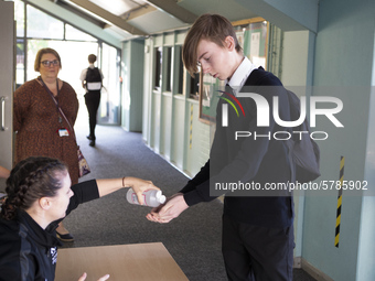   A teacher gives Year 10 pupils hand sanitizer. Ortu Gable Hall School in Corringham, Essex return after a long break due to the COVID-19 p...