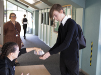   A teacher gives Year 10 pupils hand sanitizer. Ortu Gable Hall School in Corringham, Essex return after a long break due to the COVID-19 p...