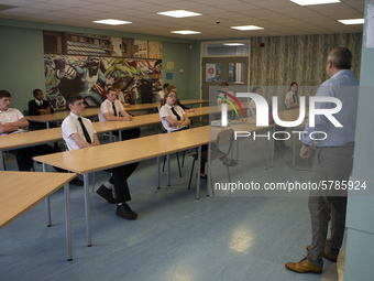   Year 10 pupils watch on as the head teacher gives a presentation . Ortu Gable Hall School in Corringham, Essex return after a long break d...