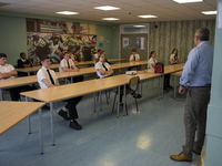   Year 10 pupils watch on as the head teacher gives a presentation . Ortu Gable Hall School in Corringham, Essex return after a long break d...