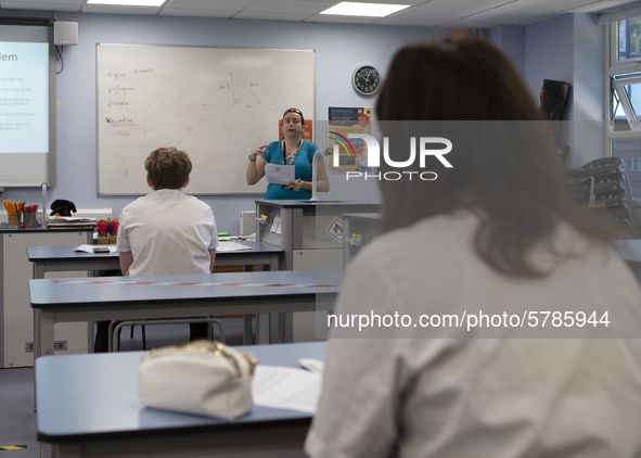   A teacher at the front of the class teaching a group of Year 10 pupils. Ortu Gable Hall School in Corringham, Essex return after a long br...