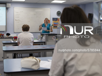   A teacher at the front of the class teaching a group of Year 10 pupils. Ortu Gable Hall School in Corringham, Essex return after a long br...