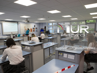   A teacher at the front of the class teaching a group of Year 10 pupils. Ortu Gable Hall School in Corringham, Essex return after a long br...