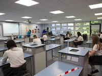   A teacher at the front of the class teaching a group of Year 10 pupils. Ortu Gable Hall School in Corringham, Essex return after a long br...